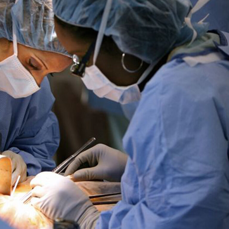 Two ENT surgeons in blue scrubs focused on a surgical procedure in a Dubai best ENT hospital.